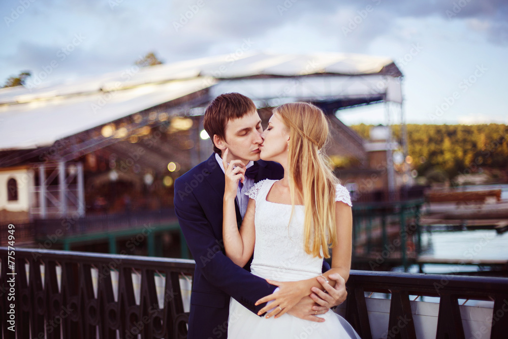 A beautiful young couple is kissing at the dock view.