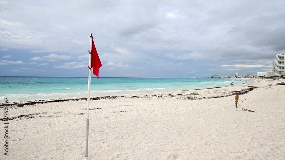 Lifeguard red flag on caribbean beach in bad weather, Cancun, Me Lifeguard red flag on caribbean beach in bad weather, Cancun, Me