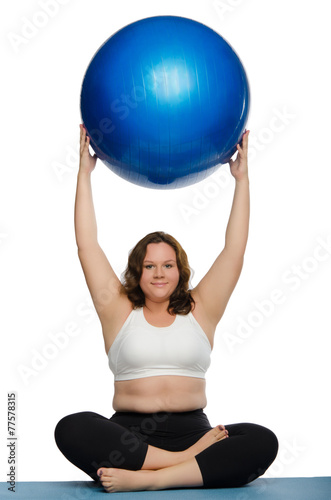 fat woman practicing yoga with blue ball