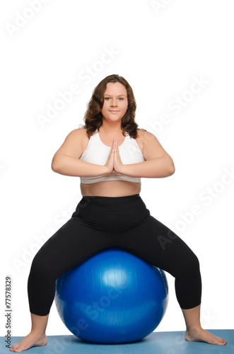 woman with overweight is sitting on blue ball