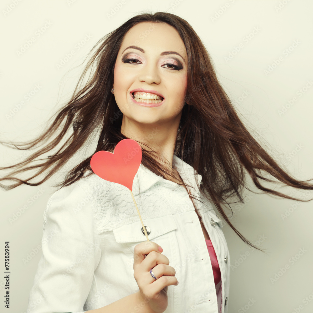 Playful young women holding a party heart Playful young women holding a party heart