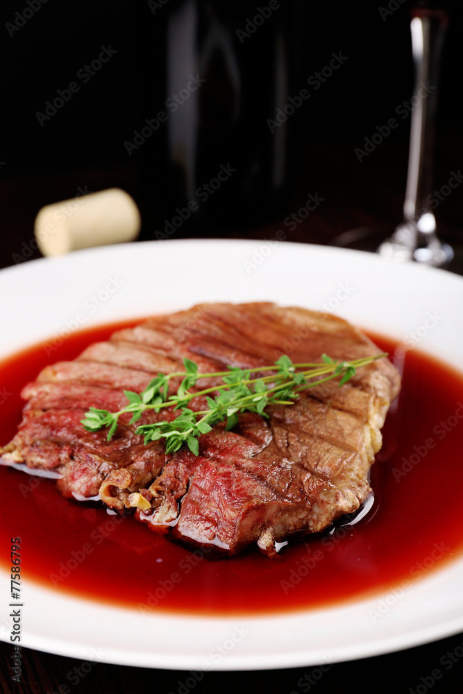 Grilled steak in wine sauce with bottle of wine Grilled steak in wine sauce with bottle of wine