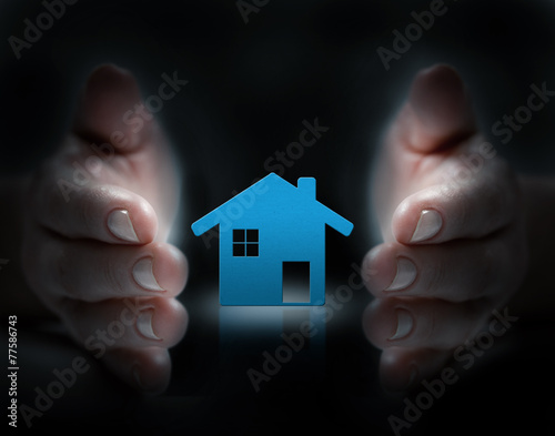 hands cover house