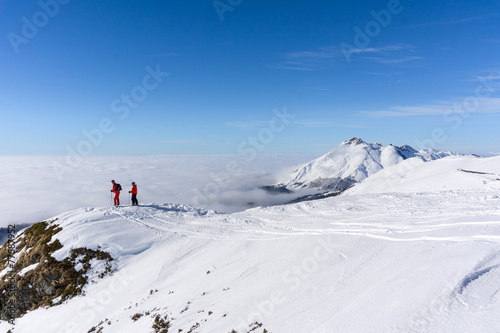 Two skiers on top of mountain above the clouds © Vasily Merkushev