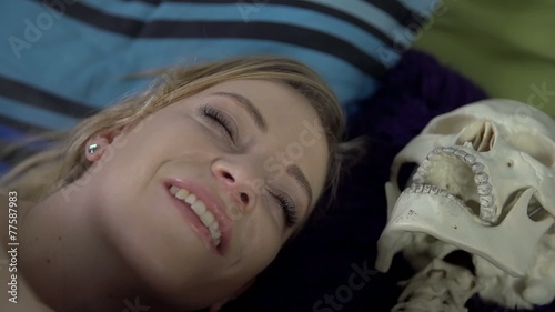 Woman is really happy to be with skeleton in the same bed
 photo