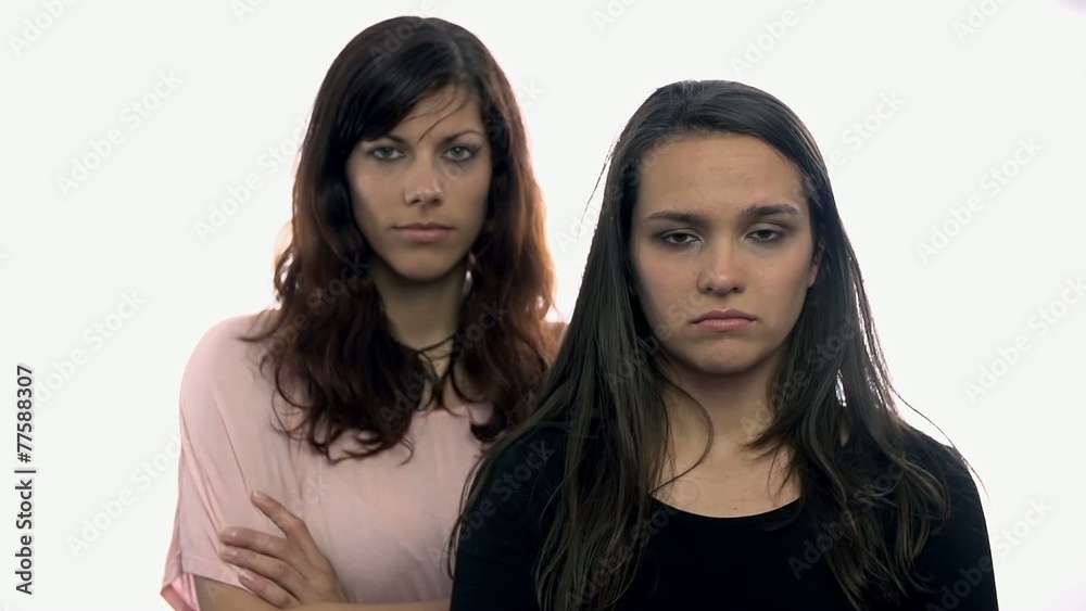 Two women looking serious in camera on white background
Two women looking serious in camera on white background