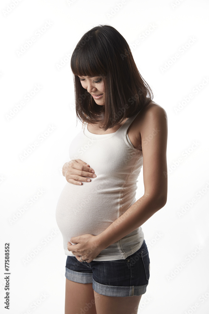 Asian pregnant woman looking and touching her belly Asian pregnant woman looking and touching her belly