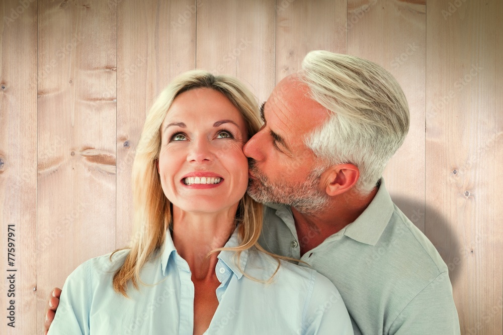 Obraz premium Affectionate man kissing his wife on the cheek