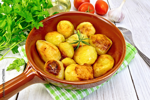 Potatoes fried in ceramic pan on light board
