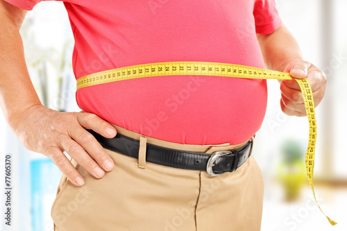 Close-up on a man measuring his belly photo