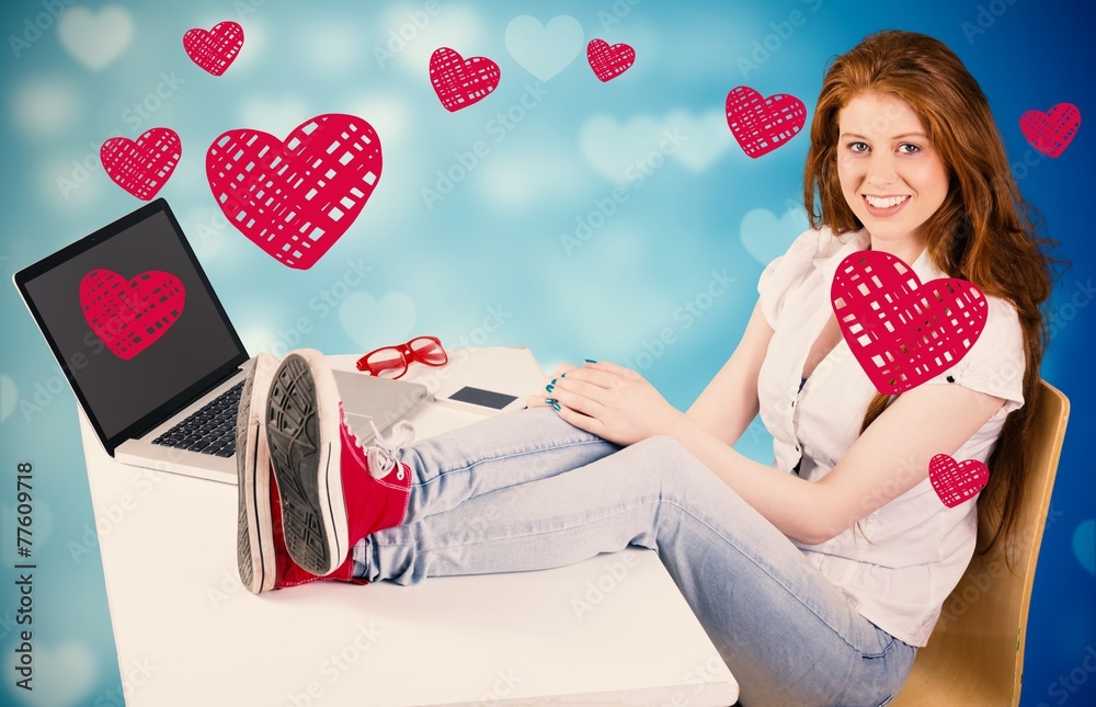 Composite image of pretty redhead with feet up on desk Composite image of pretty redhead with feet up on desk