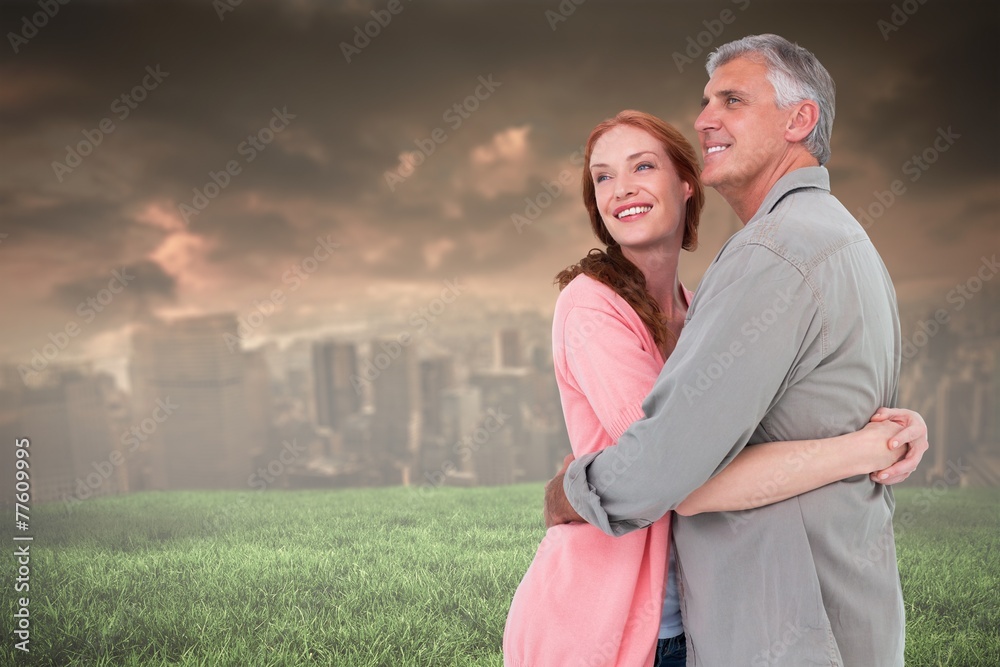 Obraz premium Composite image of casual couple hugging and smiling