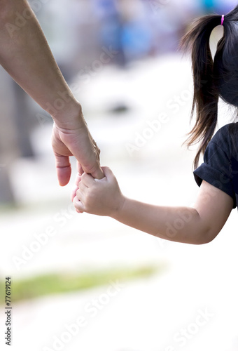 Mother lead child with hand by the hand.