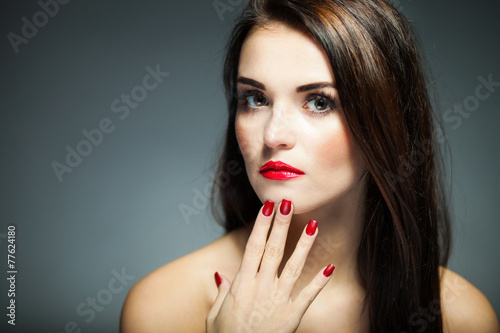 Natural woman face with red nails and lips