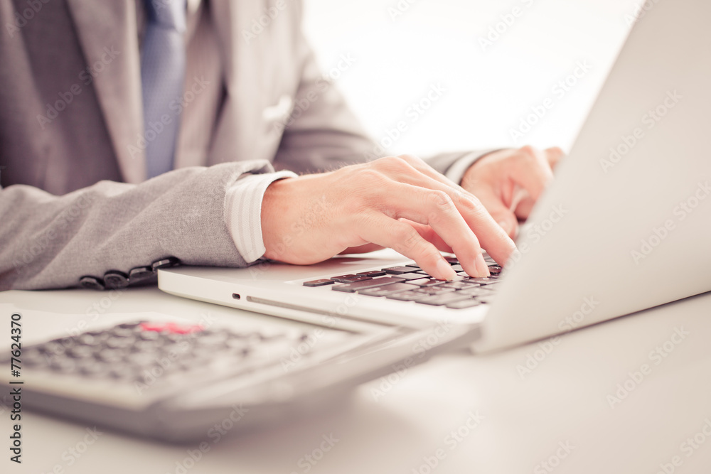 Closeup of businessman hands typing on laptop computer Closeup of businessman hands typing on laptop computer