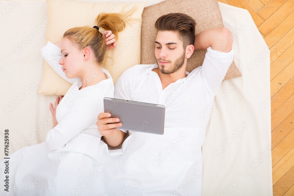 Glückliches Pärchen mit Tablet Pc im Bett Glückliches Pärchen mit Tablet Pc im Bett