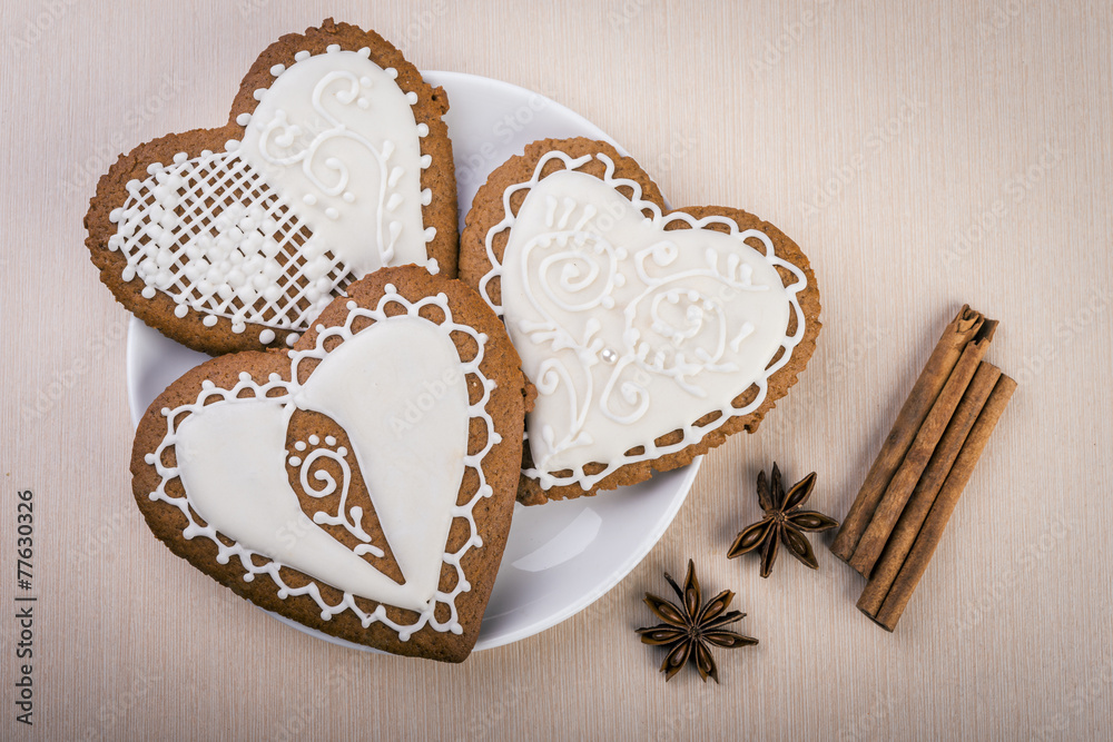 White heart shape gingerbread cookies on plate with cinnamon White heart shape gingerbread cookies on plate with cinnamon