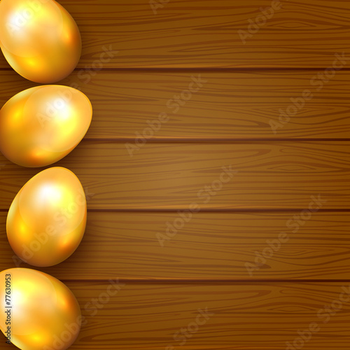 Golden eggs on wooden background