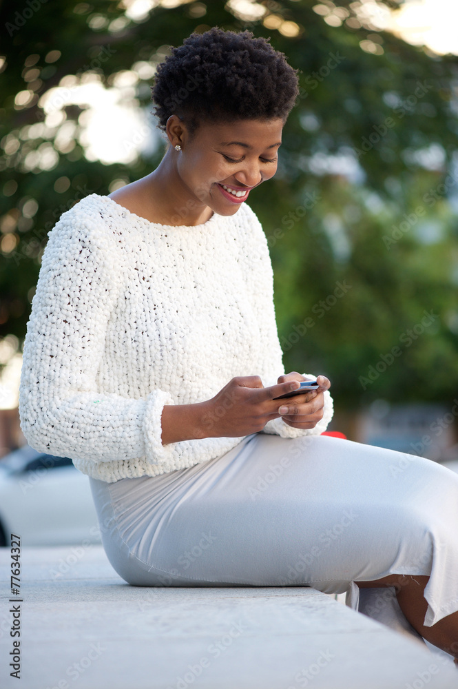 Fototapeta premium African american woman sending text message with cellphone