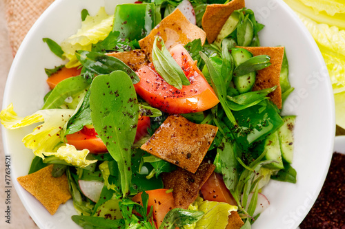 Plate of traditional Arabic salad fattouch on a wooden plate photo