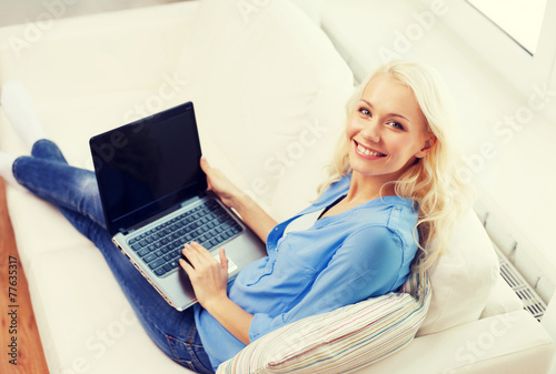 smiling woman with laptop computer at home