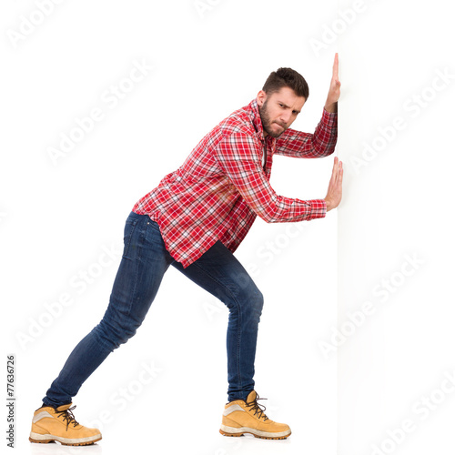 Man pushing a white wall photo