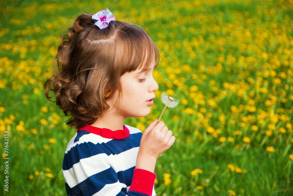 Cute child on green meadow with yellow dandelions Cute child on green meadow with yellow dandelions