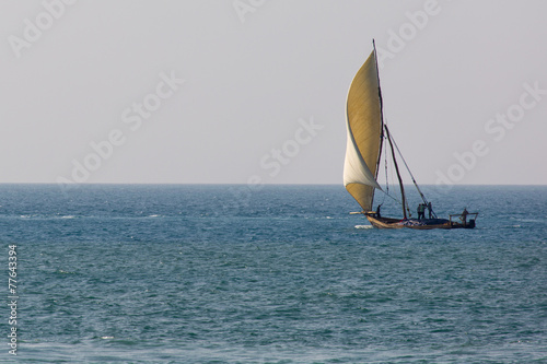 Wooden sailboat (dhow) on the clear turquoise water of Zanzibar