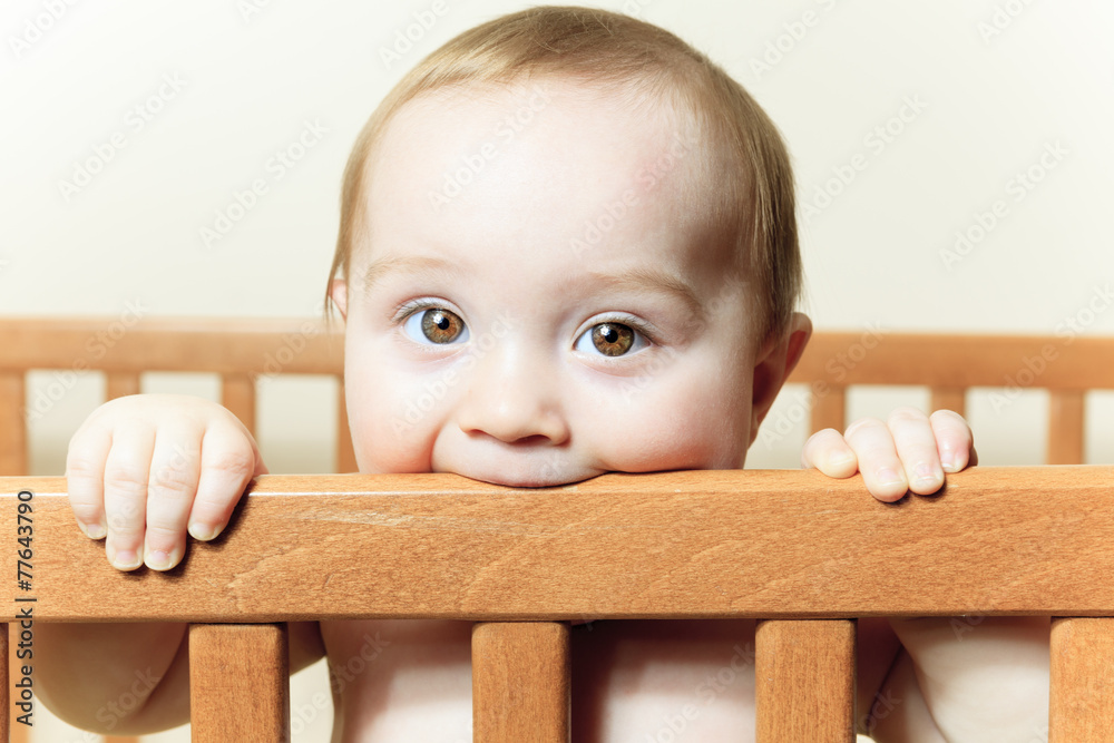 Funny little baby with beautiful standing in a round white crib Funny little baby with beautiful standing in a round white crib