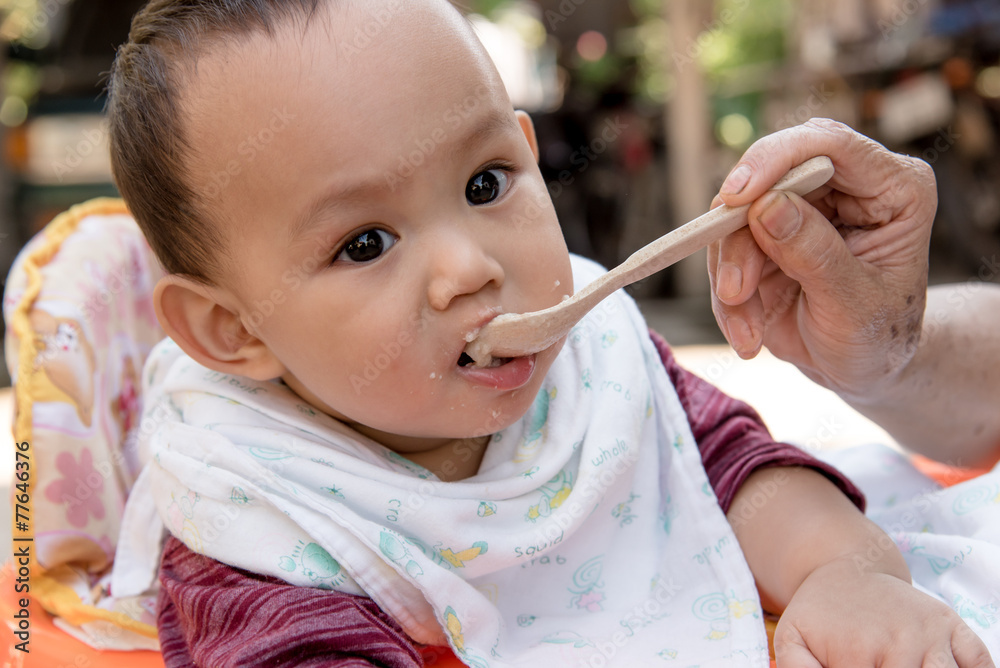 mother feeding baby eating food by spoon mother feeding baby eating food by spoon