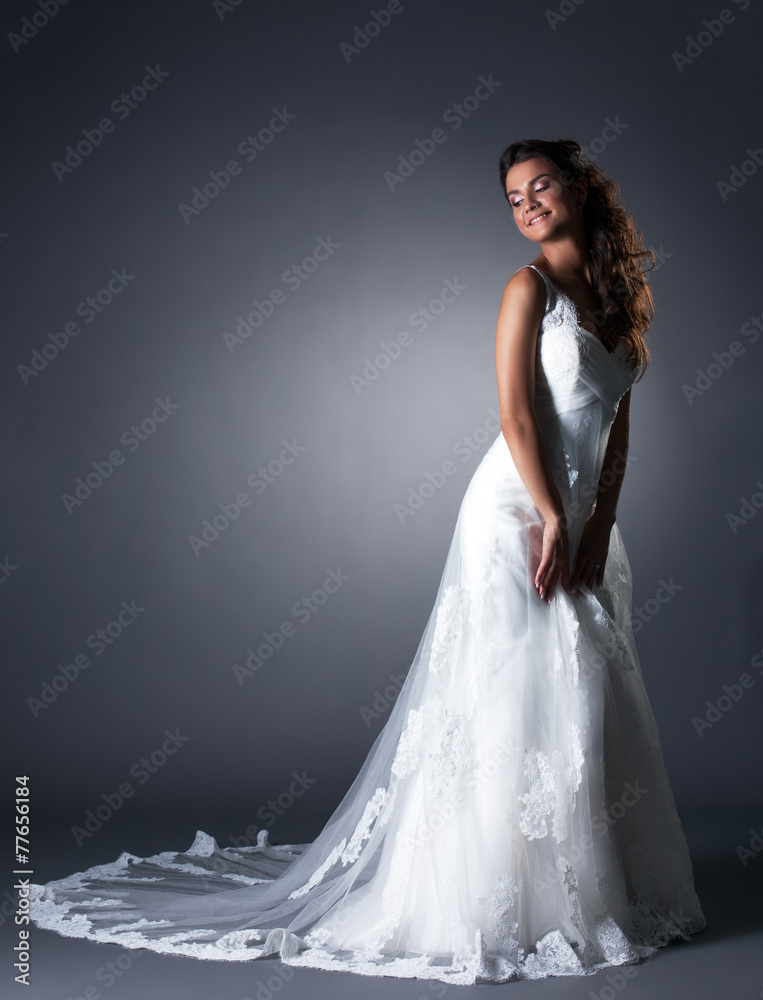 Happy bride posing in elegant wedding dress Happy bride posing in elegant wedding dress