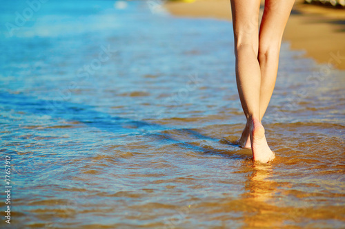 Closeup of legs of a woman on the beach