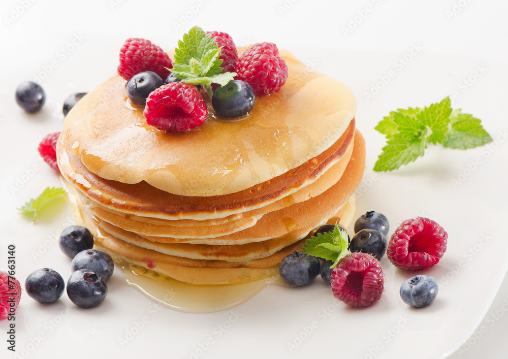 pancakes with raspberries and blueberies on a white plate pancakes with raspberries and blueberies on a white plate