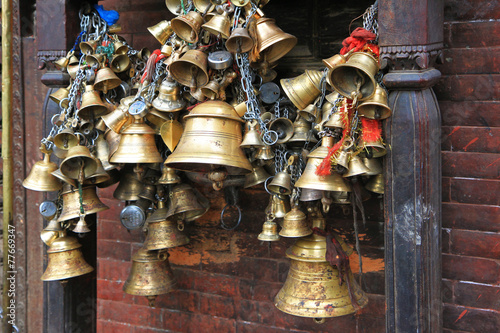 Metal sacrificial bells hanging on chain at Kumbeshwar Temple photo