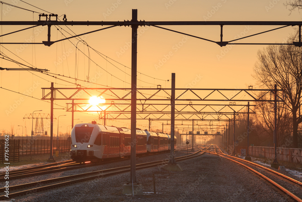 Passenger train and railroad tracks during a nice sunrise.