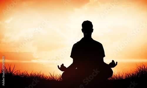 Handsome man in white meditating in lotus pose