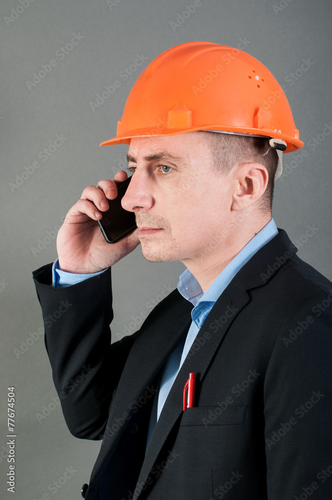 Man in tin hat calling by phone Man in tin hat calling by phone