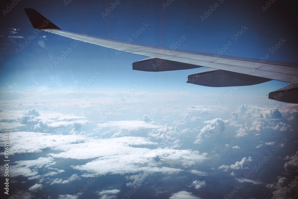 Fototapeta premium Wing of an airplane in beautiful sky with clouds