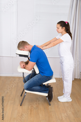 Masseuse Massaging Man's Shoulder