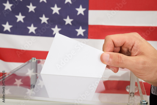 Person Casting A Ballot In Front Of Usa Flag