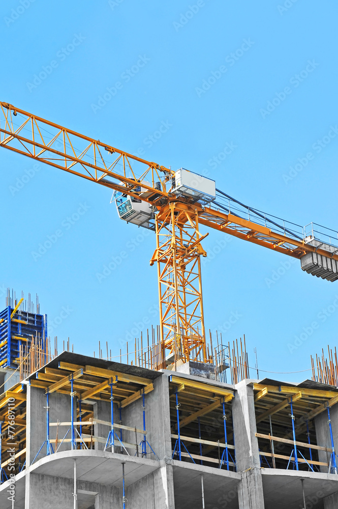 Crane and building construction site against blue sky Crane and building construction site against blue sky