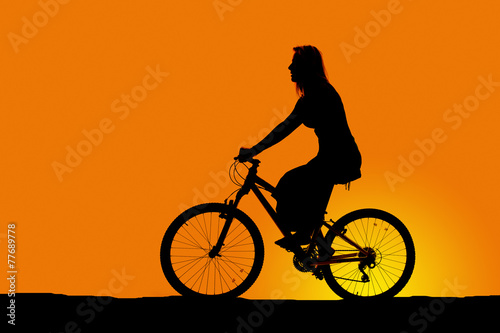 silhouette of a woman riding a bike