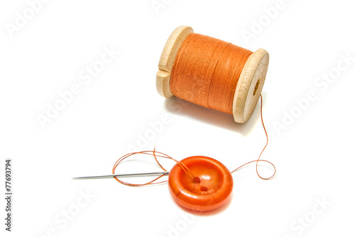 orange spool of thread, and button