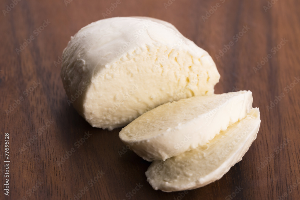 Sliced mozzarella on wooden board