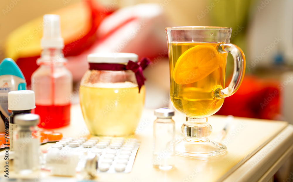 Closeup shot of tea and medicines on table next to bed Closeup shot of tea and medicines on table next to bed