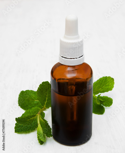 Bottle of mint oil and fresh mint