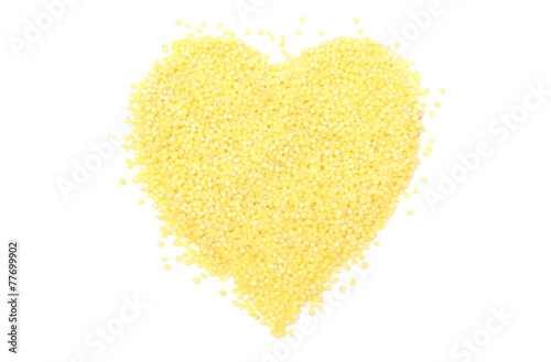 Heart shaped millet groats on white background