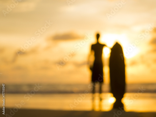 Silhouette of a surfer at sunset - intentional lens blur