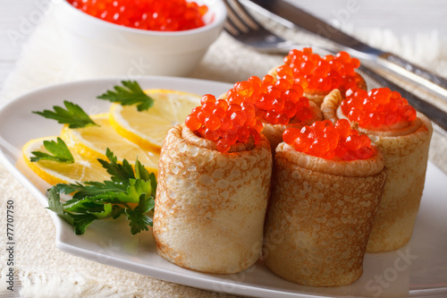Pancake rolls filled with red caviar, horizontal