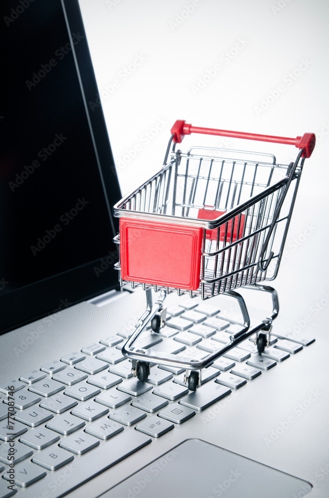 Internet shopping concept. Basket on laptop keyboard